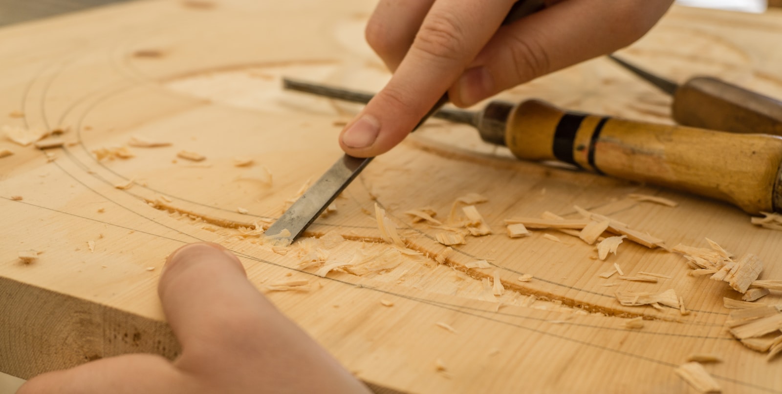 A single wooden hand plane resting on a worn workbench